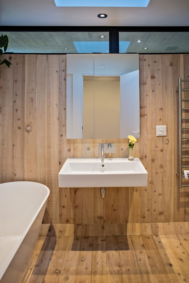 В дизайне этой современной ванной комнаты использована простая цветовая палитра - дерево и белый цвет, а в дневное время - потолочное окно, добавляющее естественный свет. # Современная ванная # Дерево # ДеревоВанная комната # Небесный свет