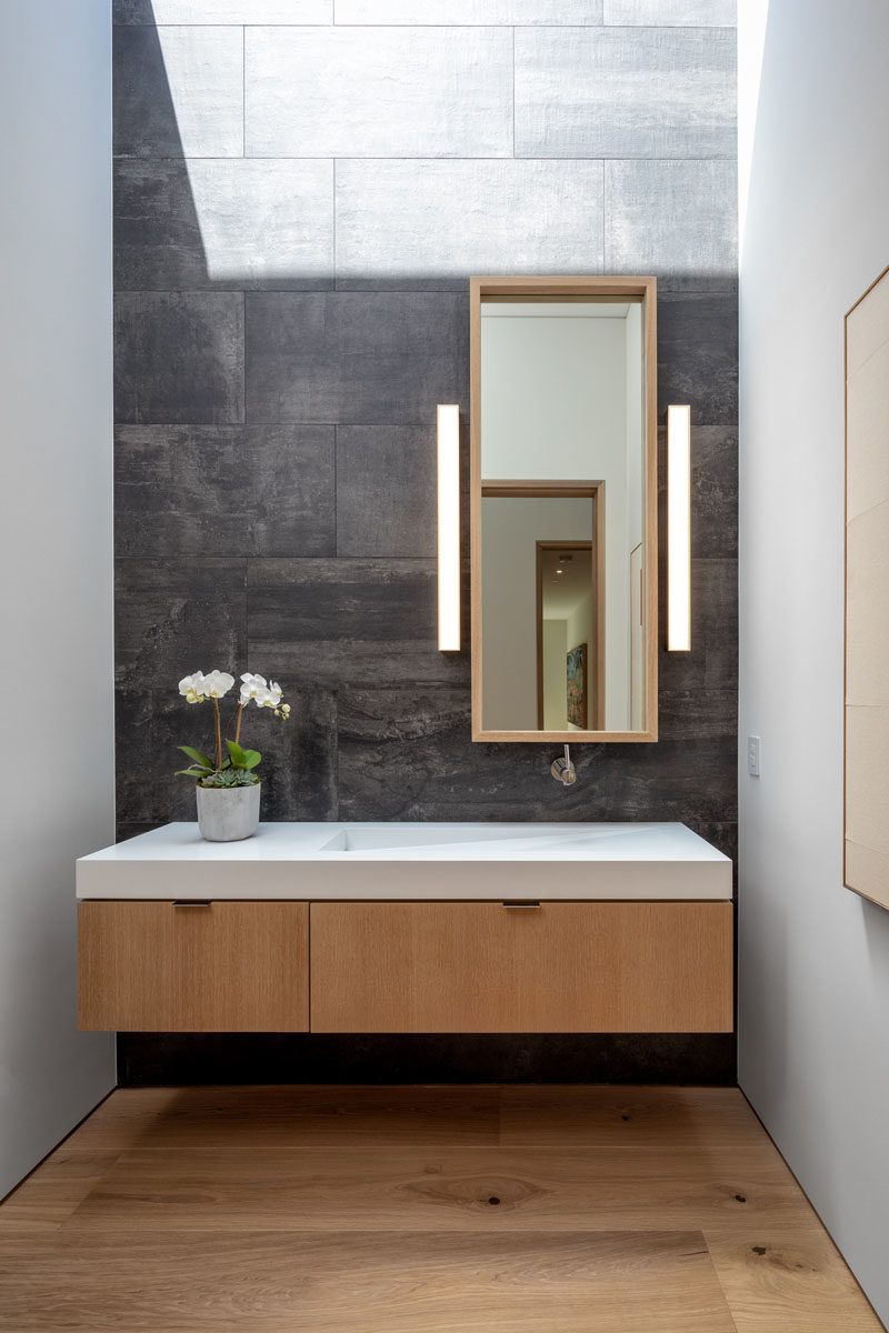 Идеи тщеславия - в этой современной ванной комнате серая плитка служит фоном для парящего деревянного туалетного столика с раковиной, встроенной в столешницу. #BathroomIdeas # Bathroom Vanity # ModernBathroom