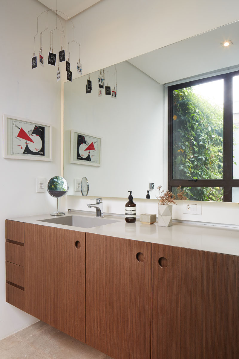  В этой современной ванной комнате есть деревянный столик со светлой столешницей, а большое зеркало отражает зеленую стену снаружи. # ВаннаяДизайн # СовременнаяВанная # ДеревоВанная 