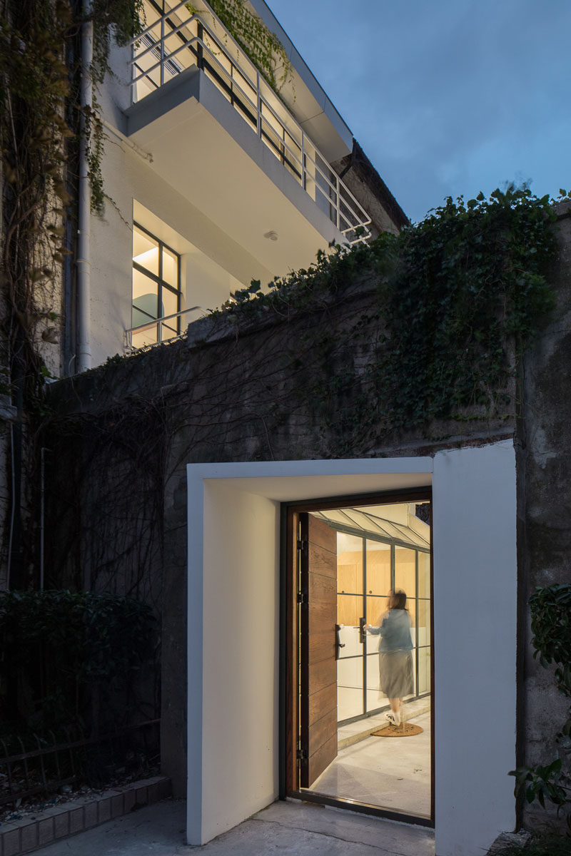  Белый подъезд и деревянная дверь этого современного дома выделяются на фоне бетона и виноградной лозы. #ModernHouseEntry #FrontDoor 