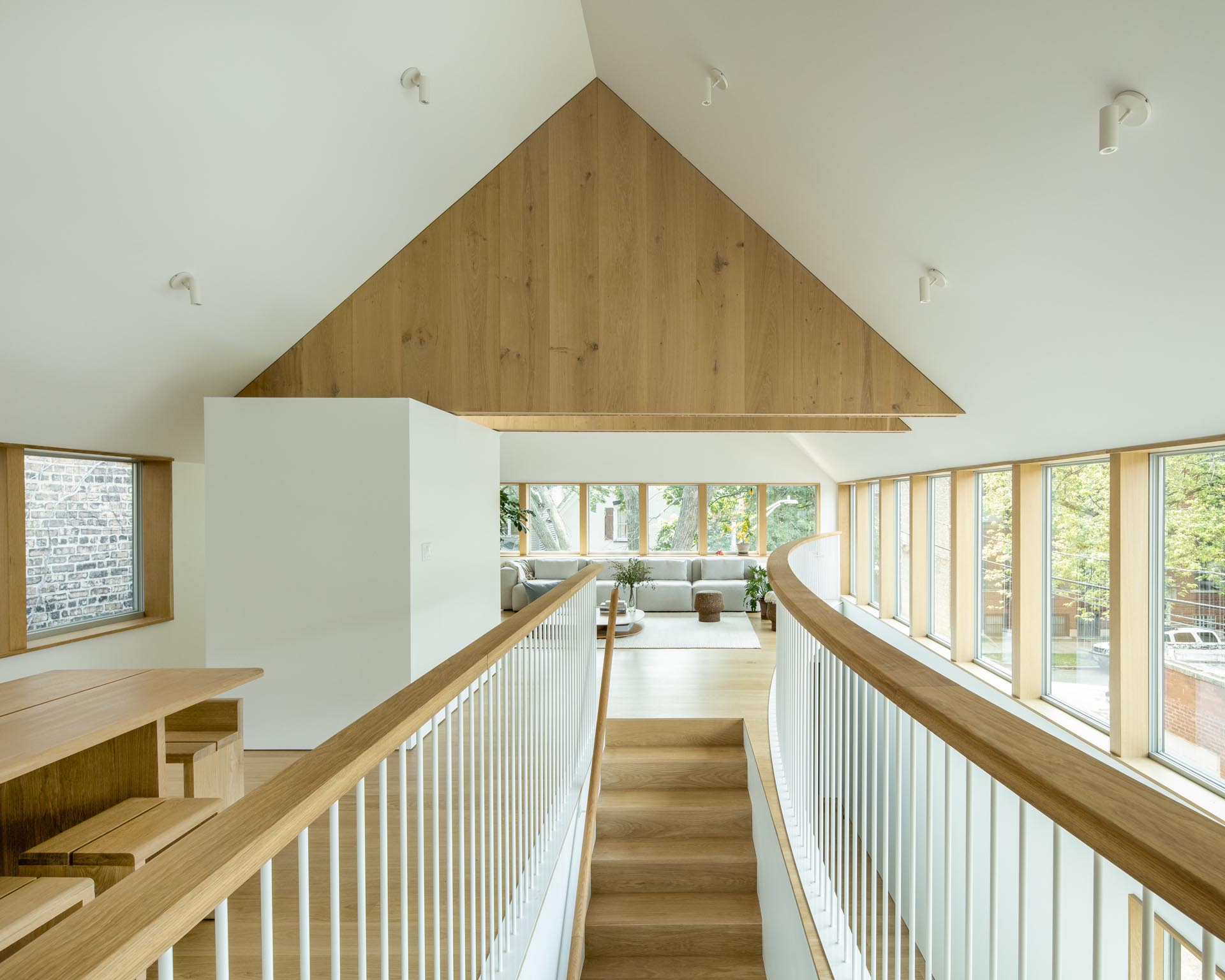 Деревянная лестница с соответствующими поручнями и перилами ведет в общественные зоны этого современного дома.