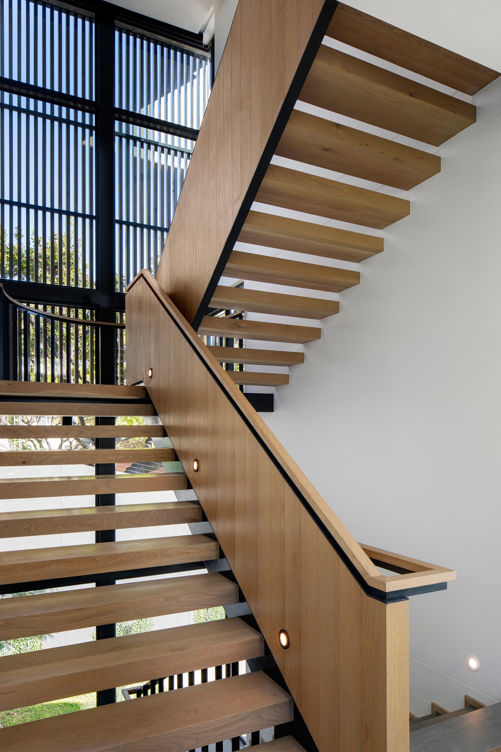 Современная деревянная лестница с черными вставками.