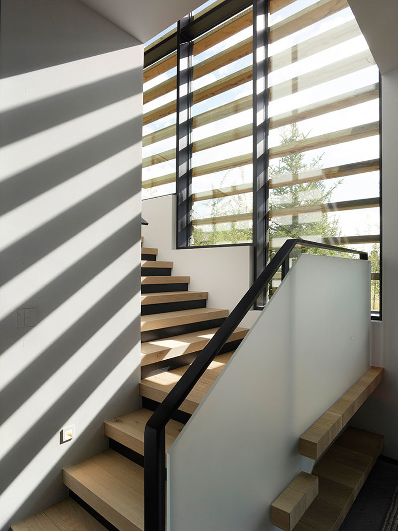 Идеи для лестниц - эти современные деревянные лестницы ведут на верхний этаж дома, а в окнах есть деревянные акценты, которые создают интересную тень на внутренних стенах. #StairIdeas #ModernStairs #StairDesign