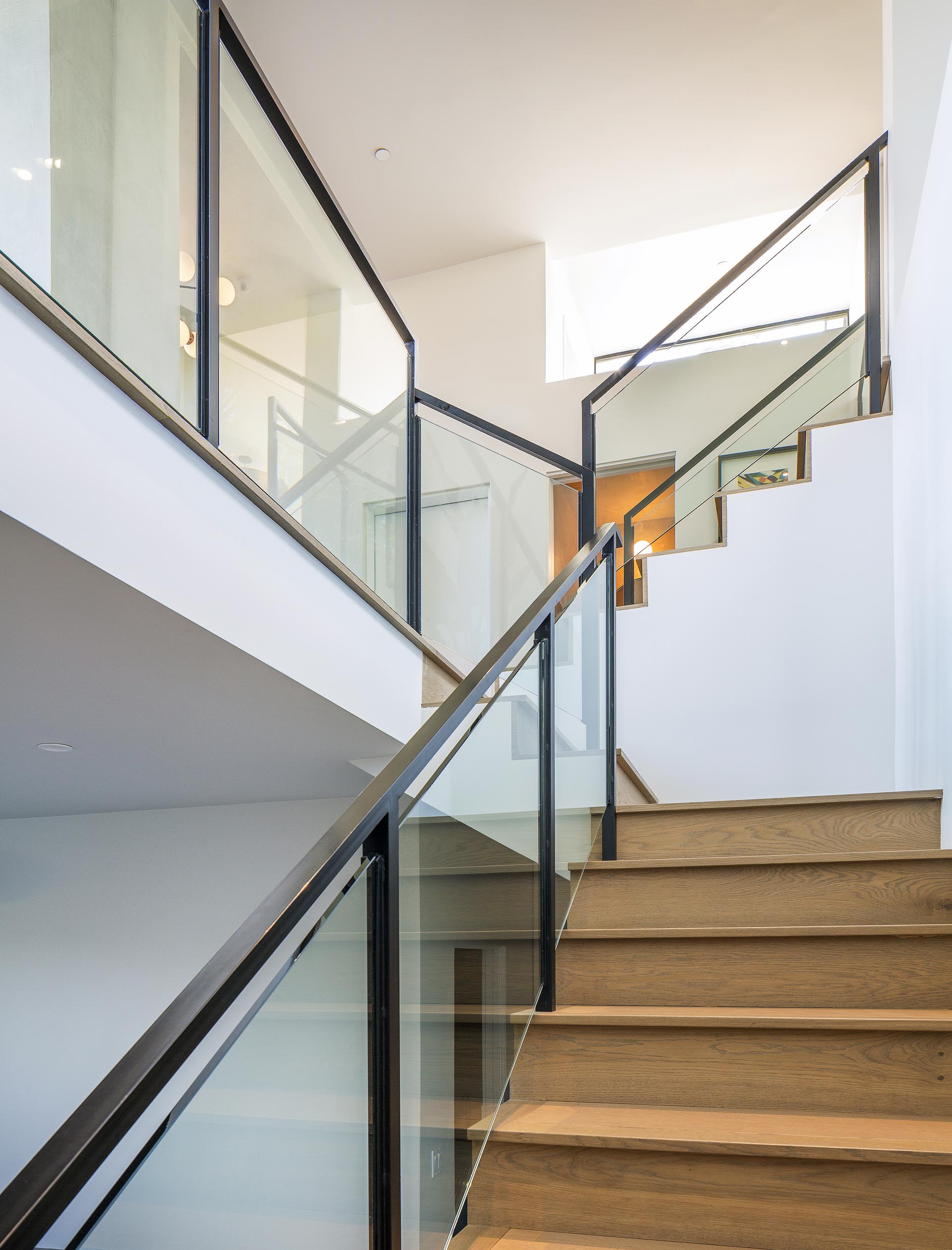 Различные уровни этого современного дома соединяют деревянные лестницы со стеклянными и металлическими перилами.