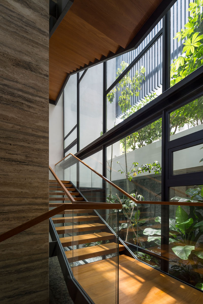 Прозрачная лестница из дерева и стали, соединяющая разные уровни этого современного дома. # Лестница # Деревянная лестница # Окна