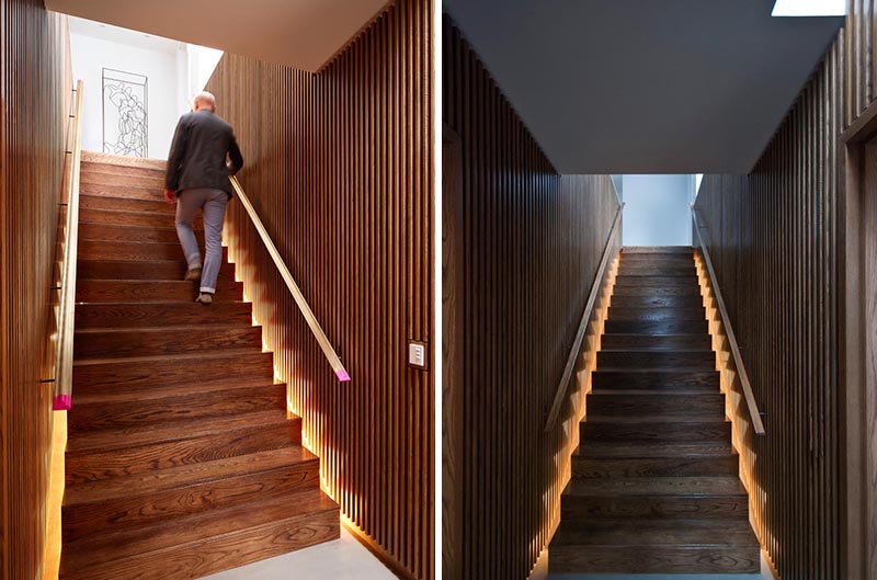 В этом современном доме есть лестница с деревянными решетчатыми стенами, перила с обеих сторон и скрытое освещение. # Дизайн лестницы # Деревянная лестница # Освещение лестницы # Скрытое освещение # Лестничные поручни