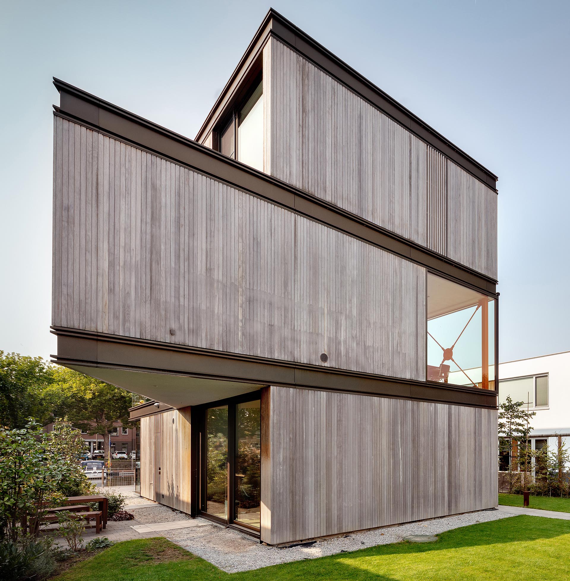 Современный дом с фасадом из дерева, металла и стекла.