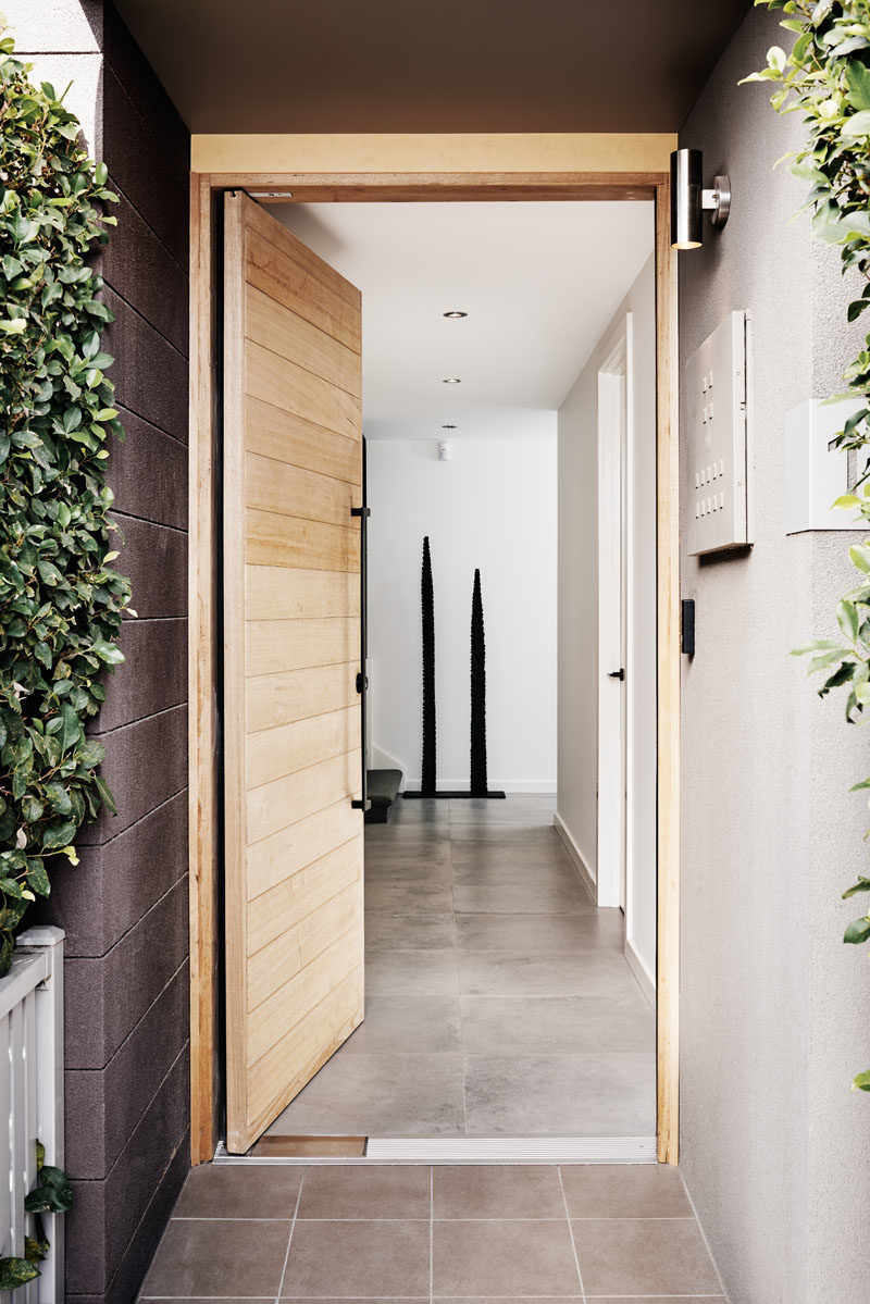 Идеи дверей - этот современный таунхаус имеет входную дверь из светлого дерева с большой современной черной вертикальной ручкой. #ModernDoor, #DoorDesign #DoorIdeas # WoodDoor