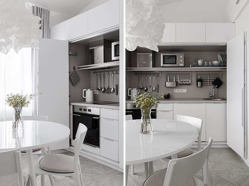 В этих современных минималистичных белых апартаментах кухня скрыта в шкафу в обеденной зоне. #MinimalistKitchen #HiddenKitchen #KitchenDesign