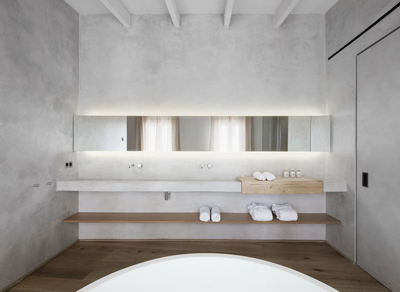 Идеи дизайна ванной комнаты - открытая полка под столешницей // Длинное деревянное покрытие под стойкой этой минималистской ванной комнаты создает место для хранения принадлежностей и добавляет пространству элемент глубины.