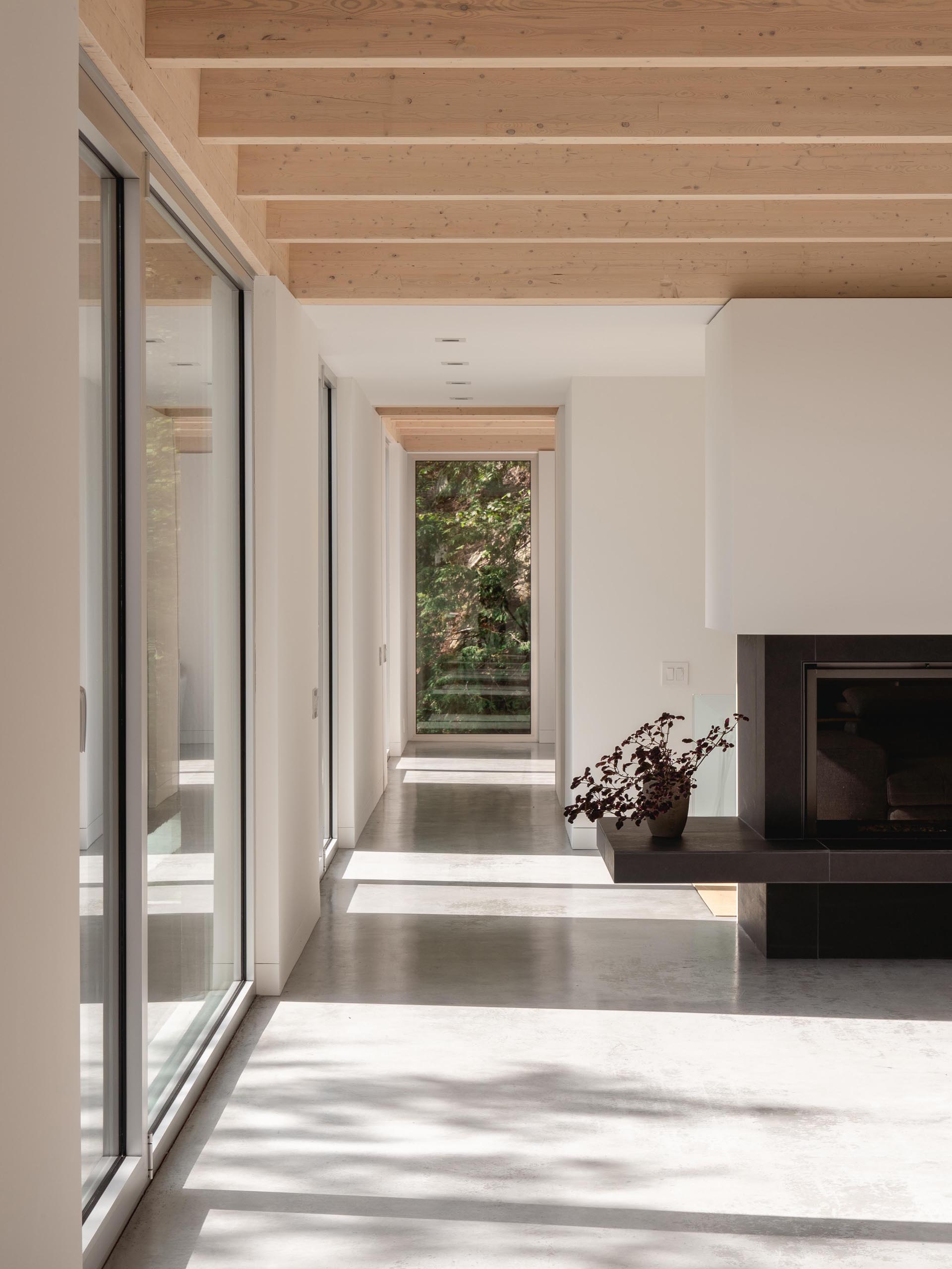 Полированный бетонный пол, гипсовые стены и окна из натурального алюминия гармонично сочетаются с деревом в этом современном доме.