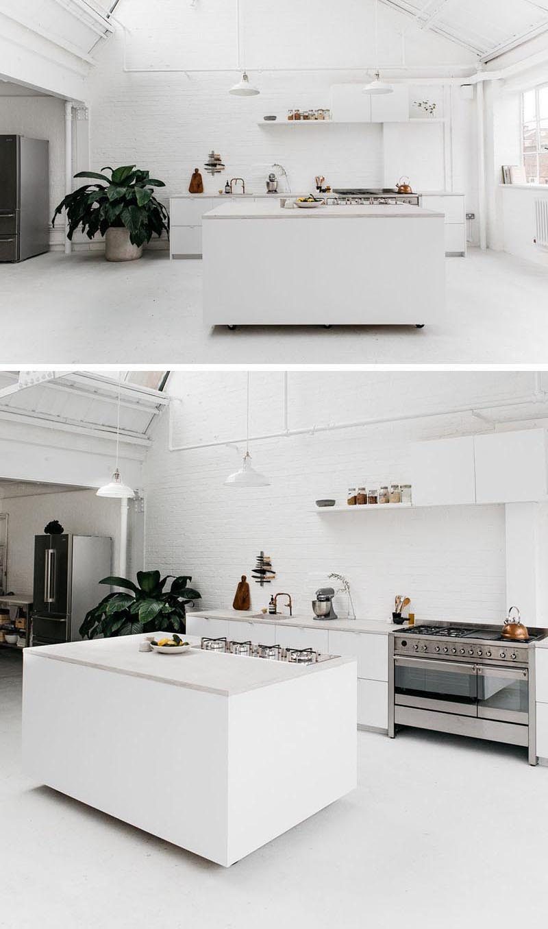 В этой ярко-белой современной кухне специально спроектированный переносной кухонный остров имеет колеса, которые несколько скрыты от глаз, создавая иллюзию парящего над землей. #PortableKitchenIsland #MovableKitchenIsland #KitchenIslandOnWheels #KitchenDesign