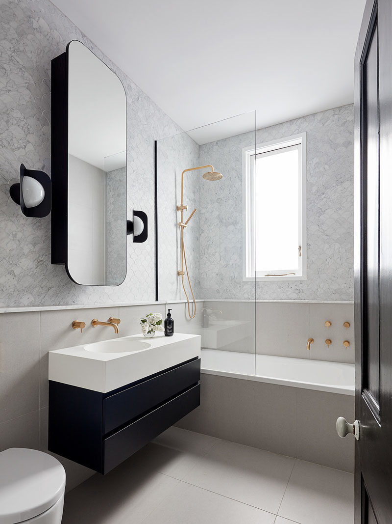 Идеи для ванных комнат - в этой современной ванной комнате круглое прямоугольное зеркало висит над небольшим черно-белым туалетным столиком, а черные бра дополняют нижнюю часть туалетного столика. Золотые штрихи добавляют пространству гламурного оттенка. #BathroomIdeas # ModernBathroom