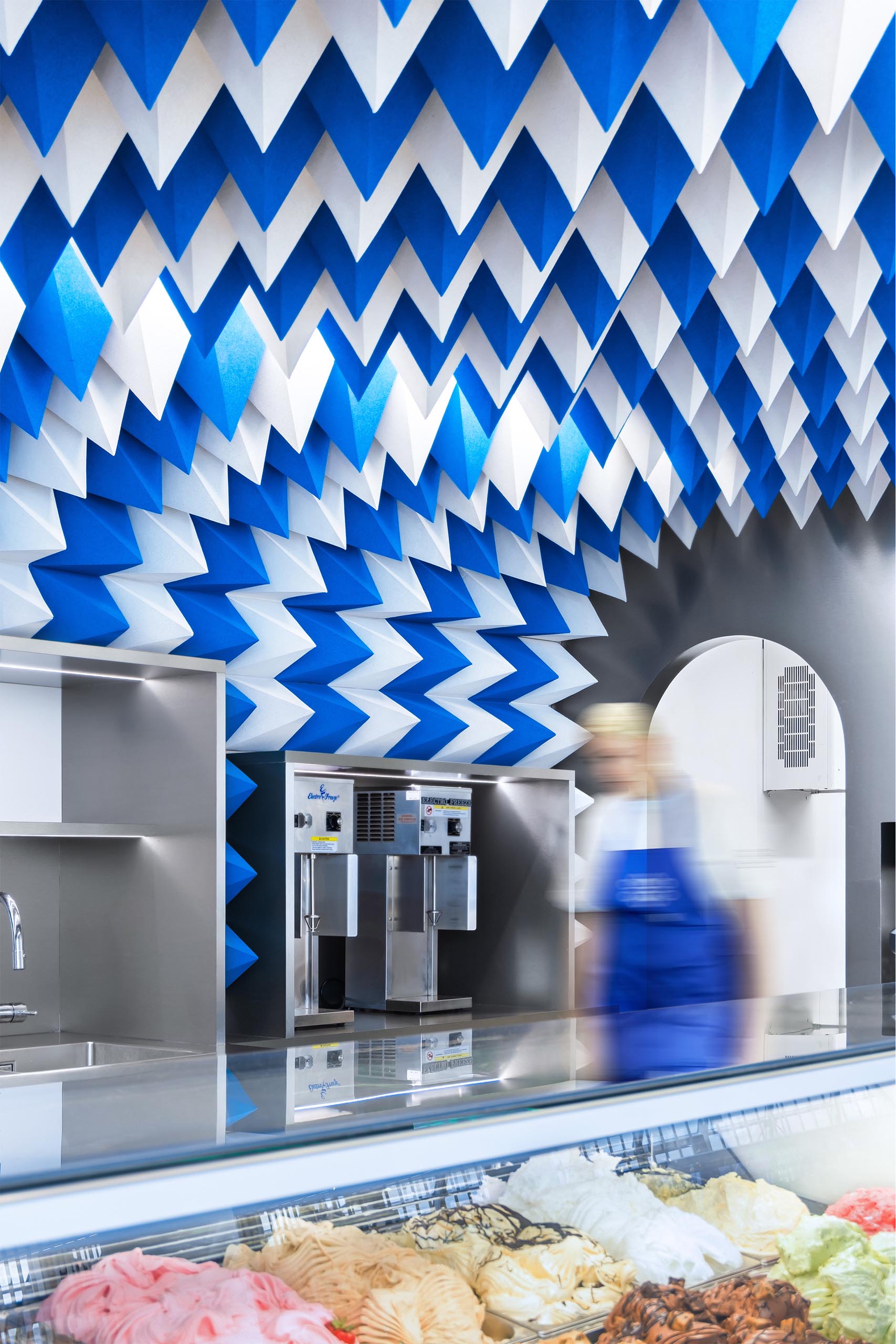 Современный магазин мороженого со скульптурной потолочной инсталляцией.