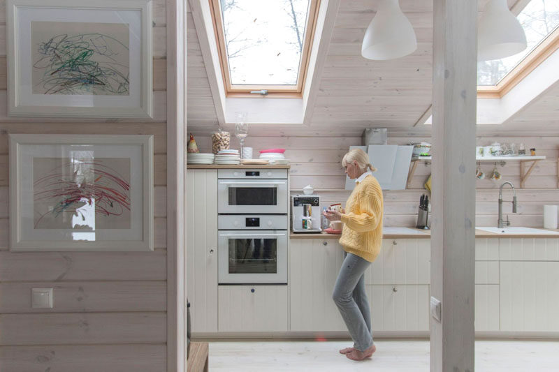  На кухне этого современного дома в загородном стиле стены украшены шкафами из светлого дерева, а потолочные окна наполняют кухню своим естественным светом. 