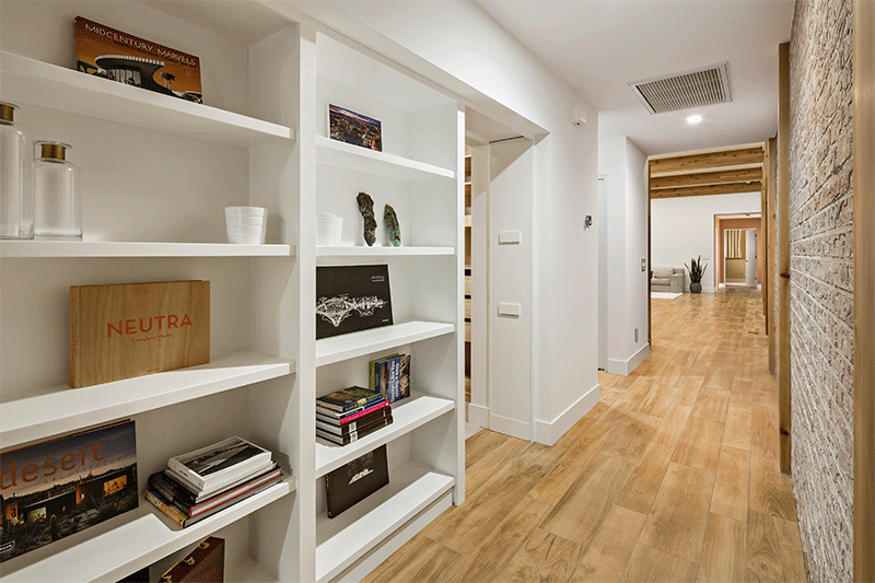 Потайная дверь во встроенном белом книжном шкафу в коридоре ведет в скрытую спальню.