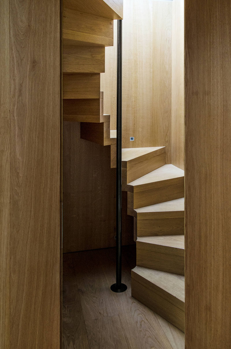 13 идей дизайна лестниц для небольших помещений // Эти компактные деревянные лестницы закручиваются вокруг черного столба, за который можно держаться при подъеме и спуске для дополнительной безопасности и поддержки.