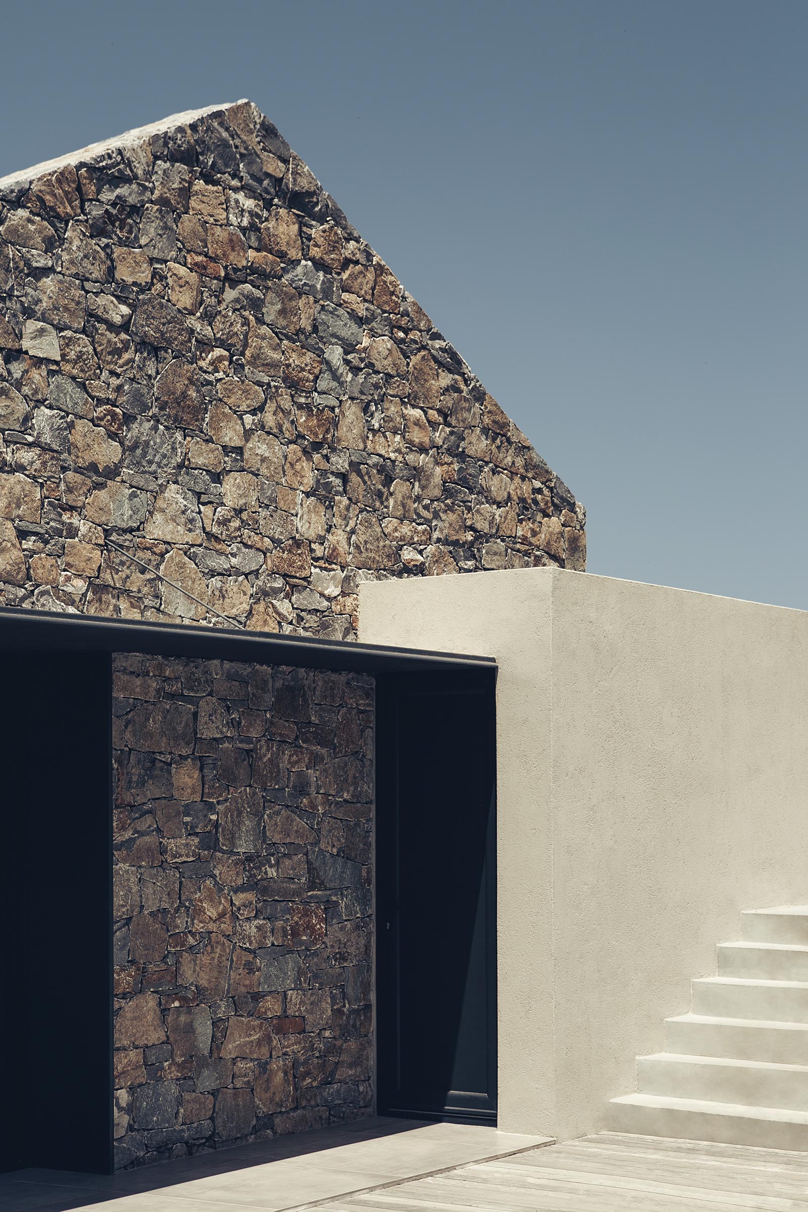 Акценты из черного металла контрастируют с каменной кладкой этого современного дома.
