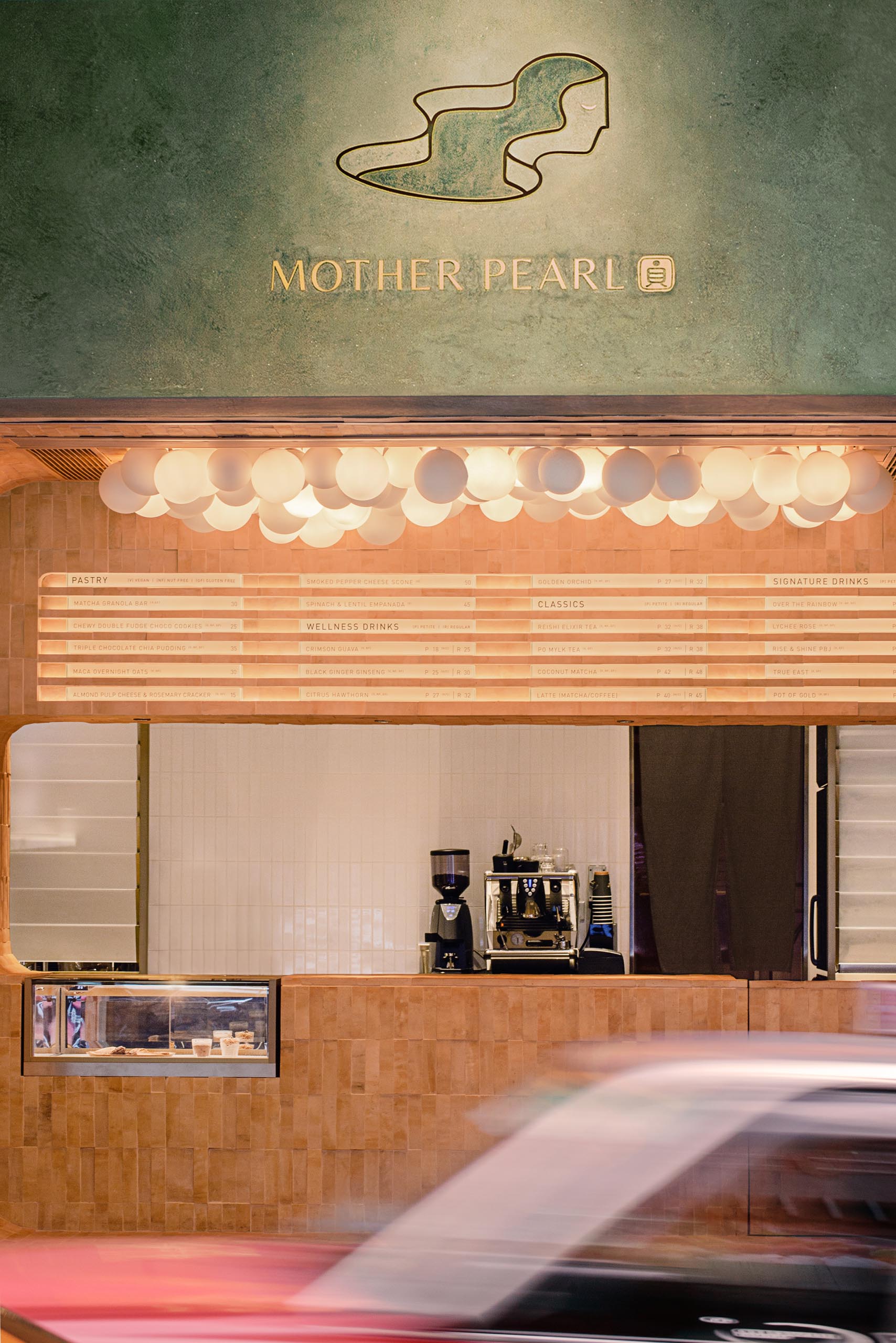 Темно-оливково-зеленый экстерьер этого чайного домика выделяется на фоне других магазинов в этом районе, а логотип выделяется на фасаде.