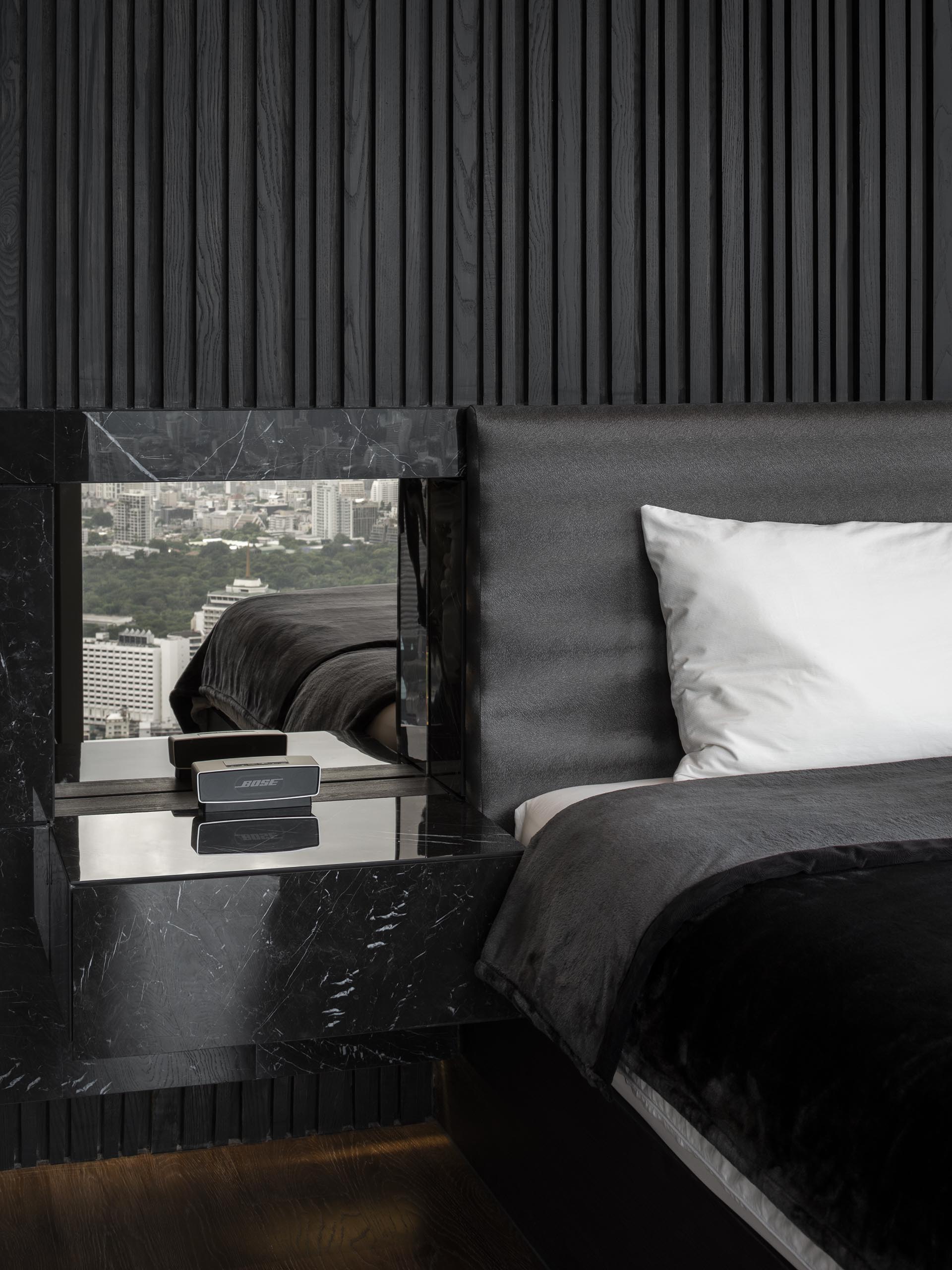 Фактурная акцентная стена из черного дерева в современной спальне.