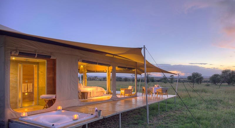 Эта сафари-палатка, поднятая на платформе с колесами, располагает собственной ванной комнатой за спальной зоной, в которой есть туалет со смывом, умывальник и душ. На палубе по периметру также установлена ​​ванна на уровне пола. #Serengeti #SafariCamp #SafariTent