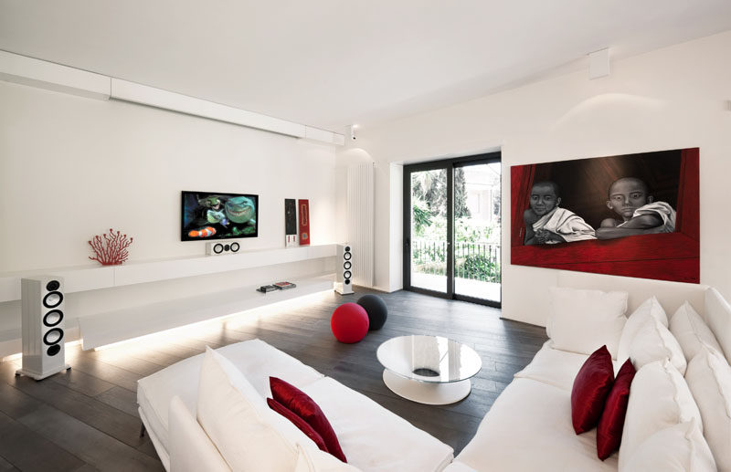 8 идей дизайна телевизионных стен для вашей гостиной // Телевизор и звуковая система в этой гостиной, оформленной в бело-красных тонах, почти не окружены чем-то другим, что делает их основным элементом интерьера.
