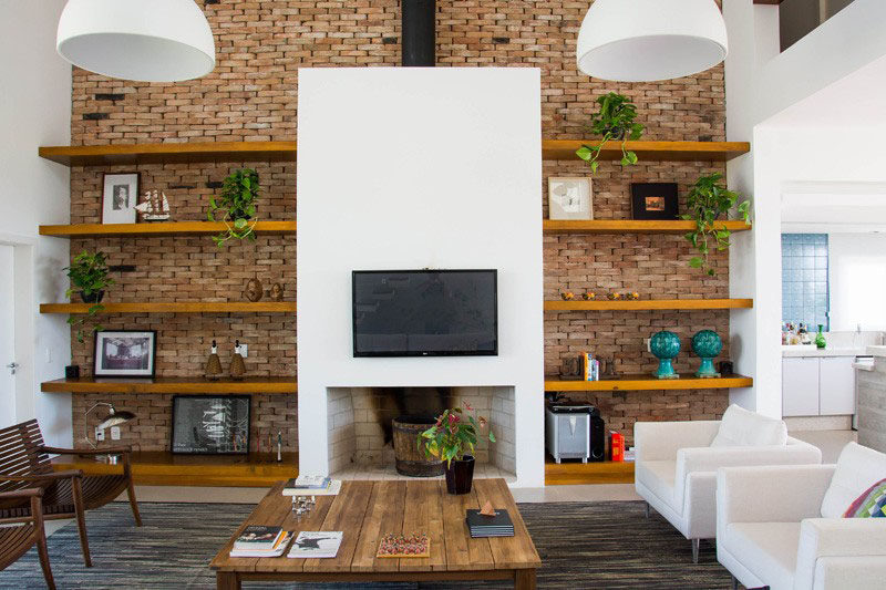 8 идей дизайна телевизионных стен для вашей гостиной // Под этим телевизором находится настоящий камин, который также окружен местом для хранения вещей, чтобы создать удобную и практичную гостиную.