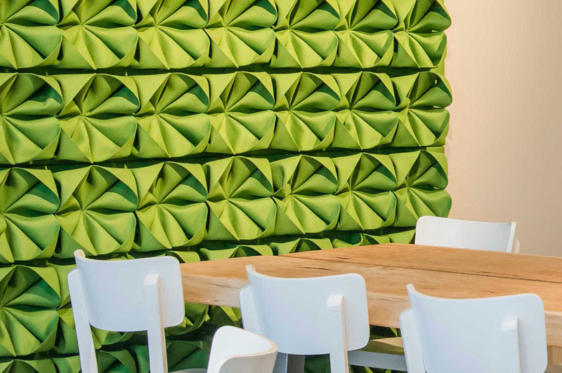 Замысловато сложенные кусочки зеленого фетра, прикрепленные к этой акцентной стене, придают ей объем и текстуру, а также делают комнату ярче.