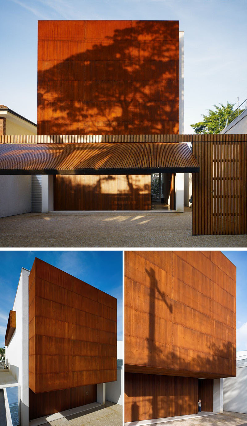 Атмосферостойкая сталь этого современного дома соответствует тону используемого дерева для отделки гаражных и входных дверей, и придает фасаду текстурированный и уникальный вид.