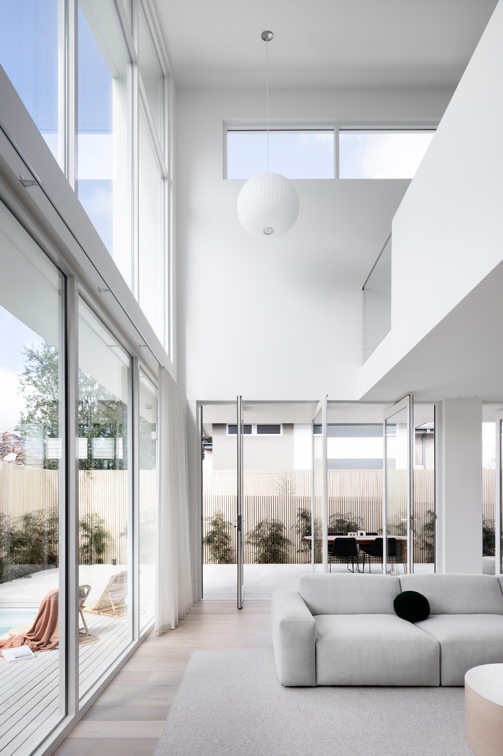 Поворотные части стеклянных стен соединяют внутреннее пространство с внешним миром этого современного дома.