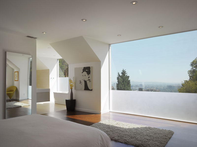 Частично матовое окно обеспечивает уединение современной спальне и ванной.