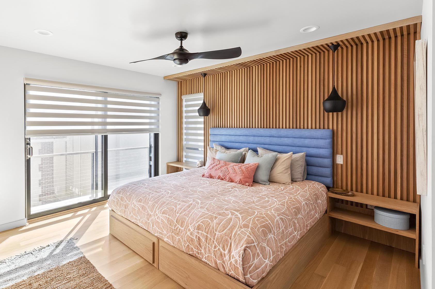 Современная спальня с деревянной стеной.