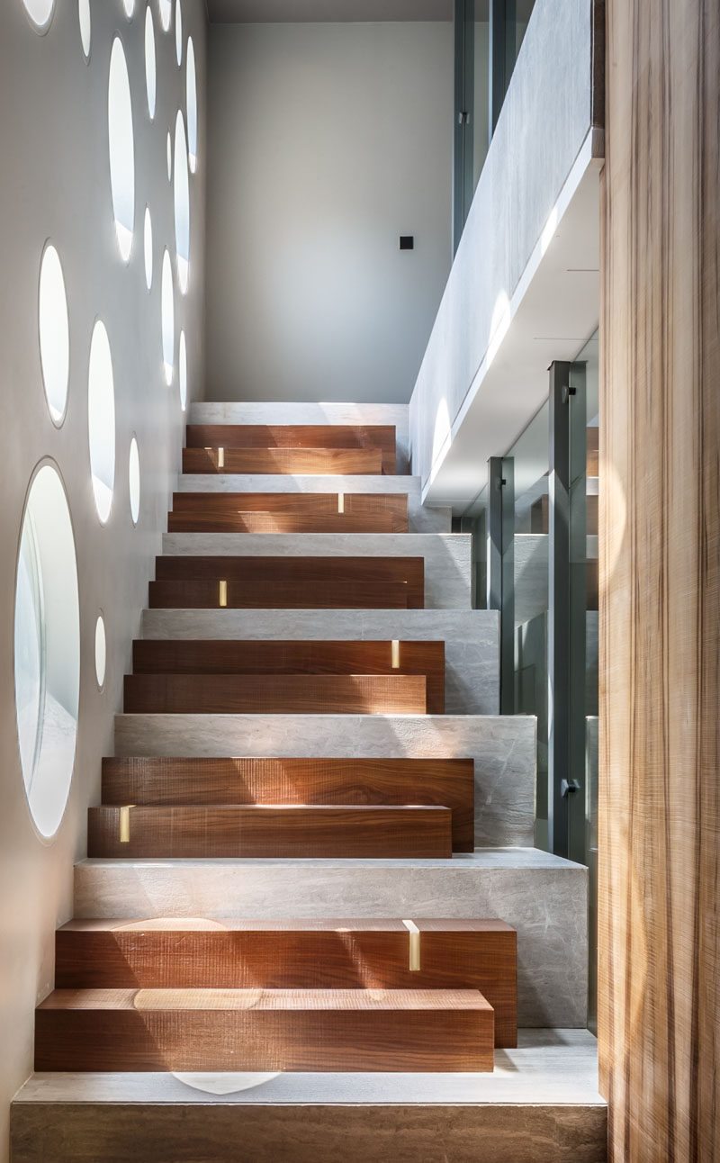 В конструкции этой лестницы деревянные ступени сочетаются с бетонным основанием, а светодиодные ленты добавляют неброское освещение. #ModernStairs #StairDesign