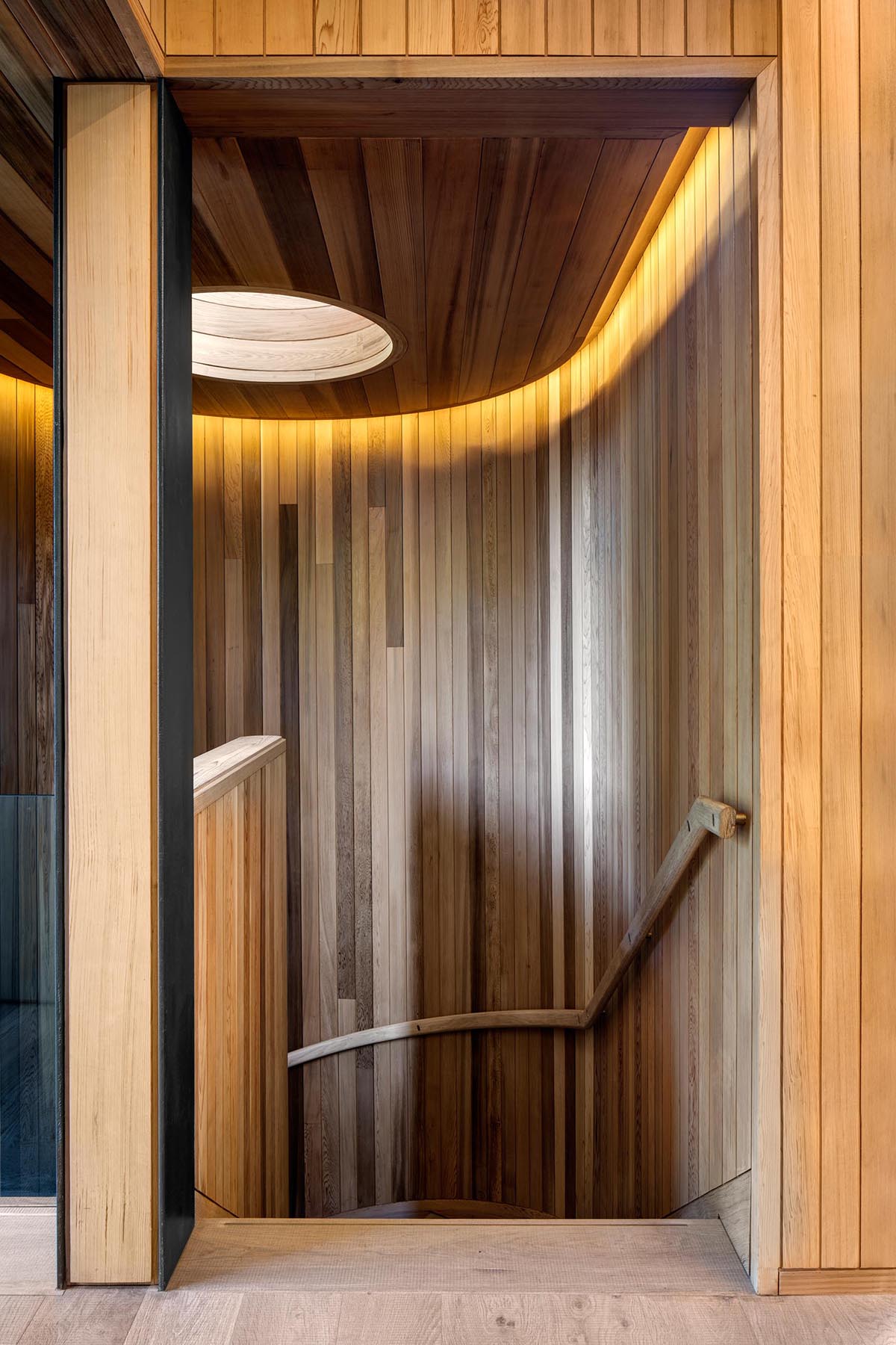 Современная деревянная лестница с застекленным светом и скрытым освещением.