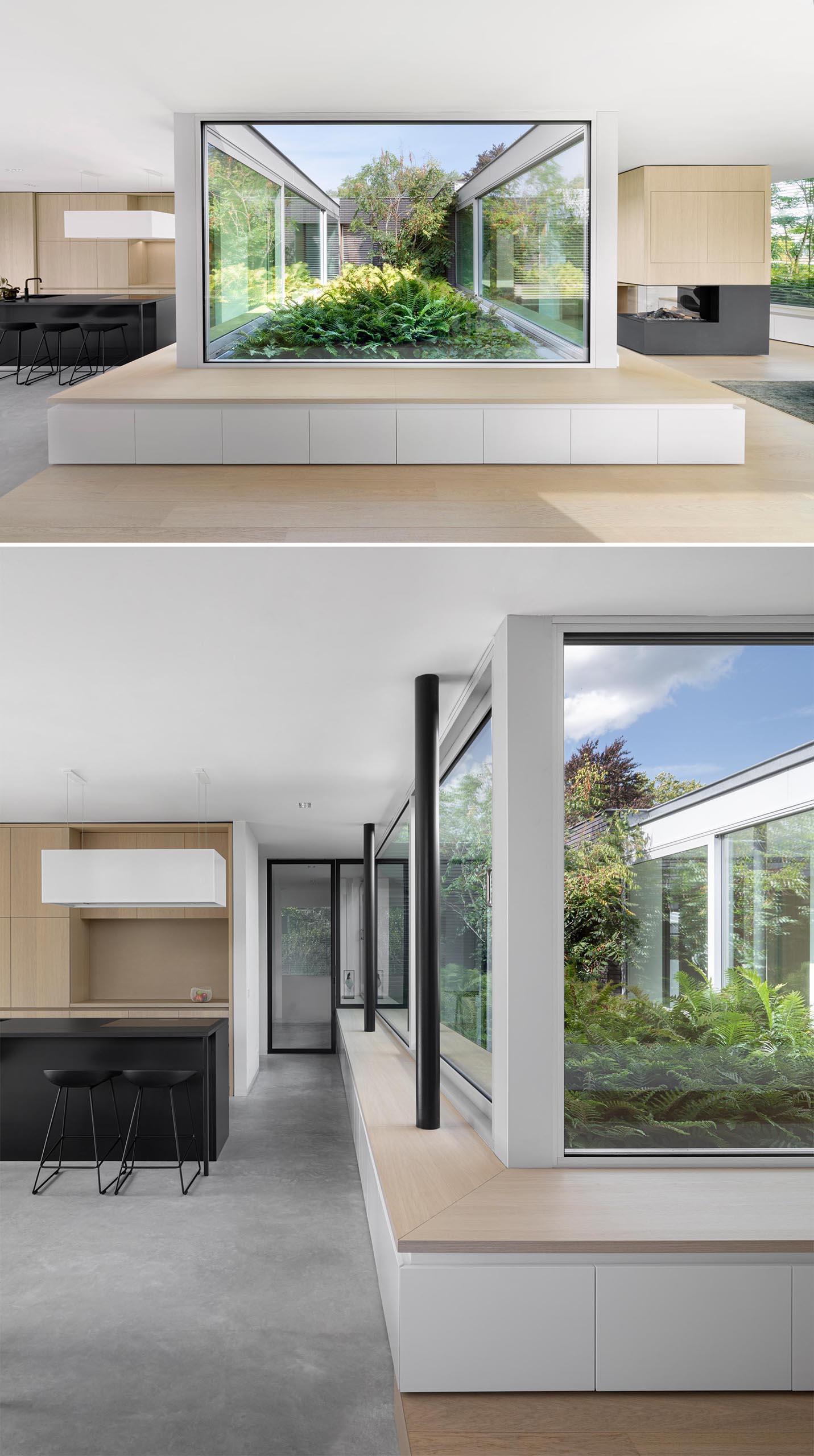 Современный дом с деревянной скамейкой, которая огибает окна и обеспечивает вид на зеленый сад.